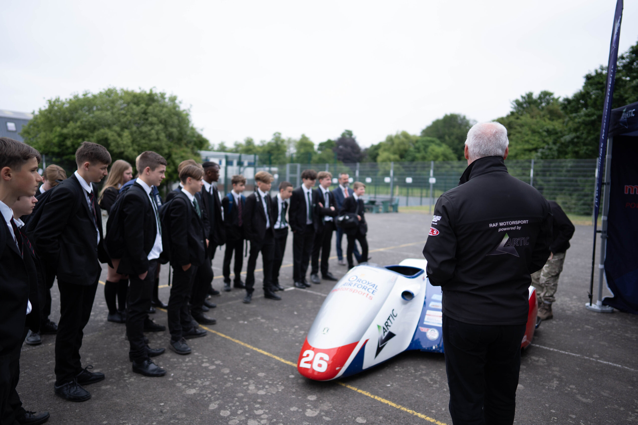 A group of students outside looking at a model